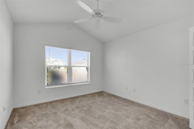 carpeted spare room featuring ceiling fan and vaulted ceiling