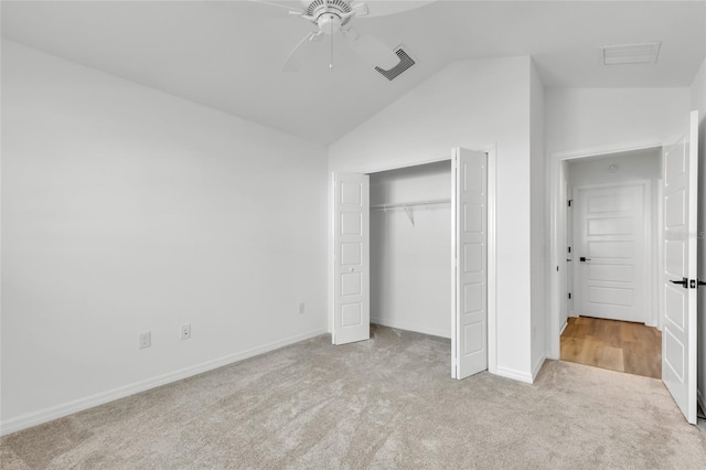 unfurnished bedroom featuring lofted ceiling, light colored carpet, ceiling fan, and a closet