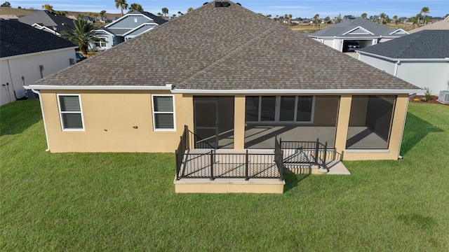 rear view of property with a sunroom and a yard