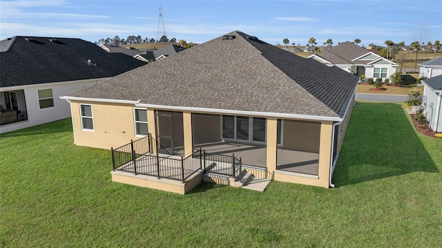 back of property with a sunroom and a lawn