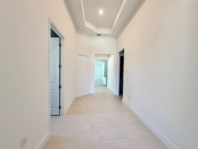 hallway featuring a raised ceiling