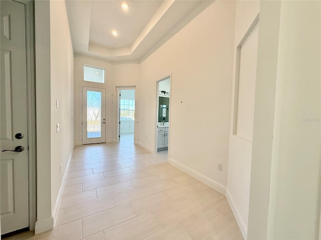 interior space with light tile patterned floors and a raised ceiling