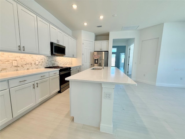 kitchen featuring white cabinets, sink, a kitchen island with sink, and appliances with stainless steel finishes