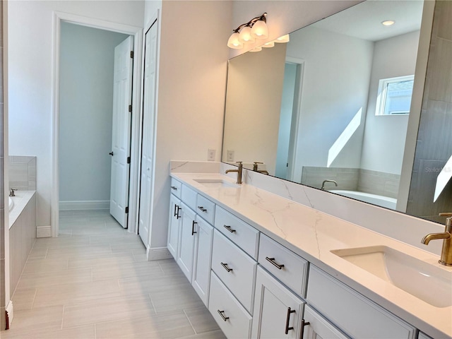 bathroom with tile patterned floors, tiled tub, and vanity