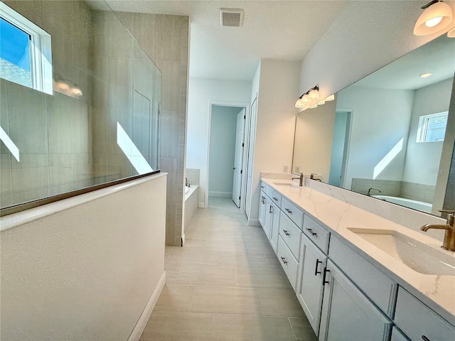 bathroom featuring tile patterned flooring, vanity, and separate shower and tub