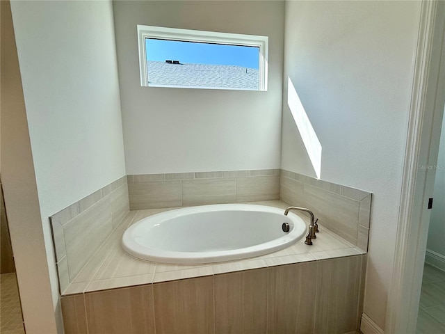 bathroom featuring tile patterned flooring and tiled tub