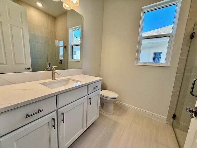 bathroom with vanity, an enclosed shower, and toilet