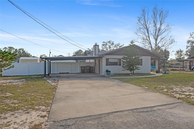 single story home featuring a front lawn and a carport