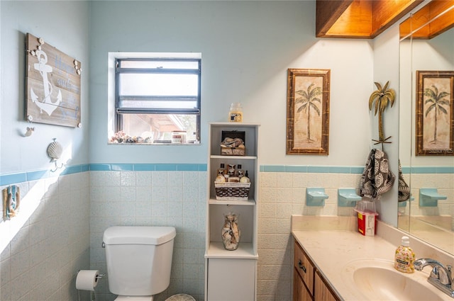 bathroom with vanity, tile walls, and toilet