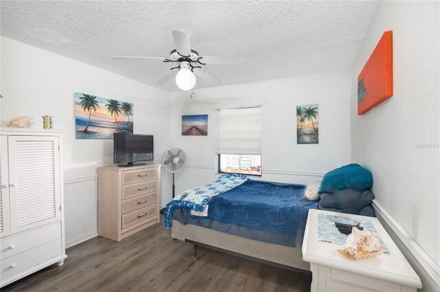 bedroom with a textured ceiling, dark hardwood / wood-style flooring, and ceiling fan