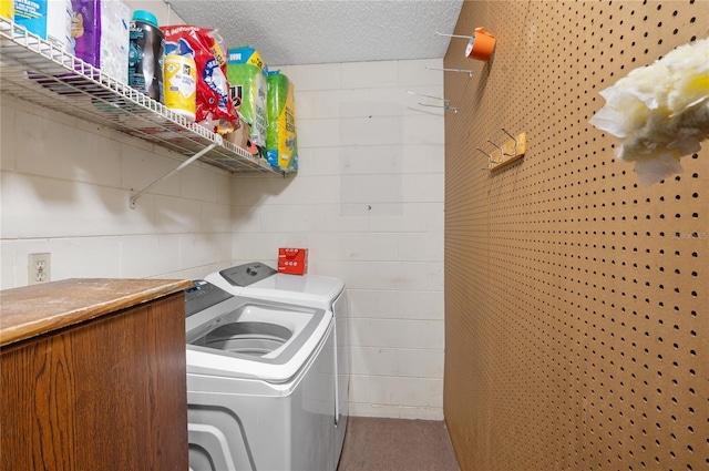 laundry area with washer and dryer and a textured ceiling