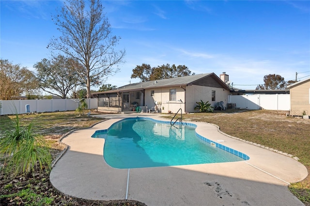 view of swimming pool with a lawn and a sunroom