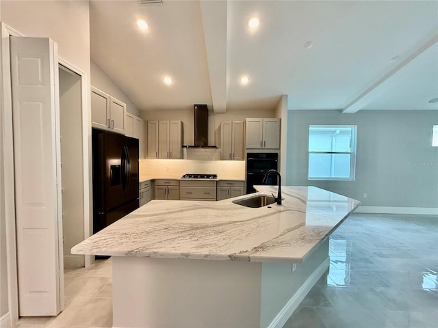 kitchen featuring beamed ceiling, gray cabinets, a spacious island, and wall chimney range hood