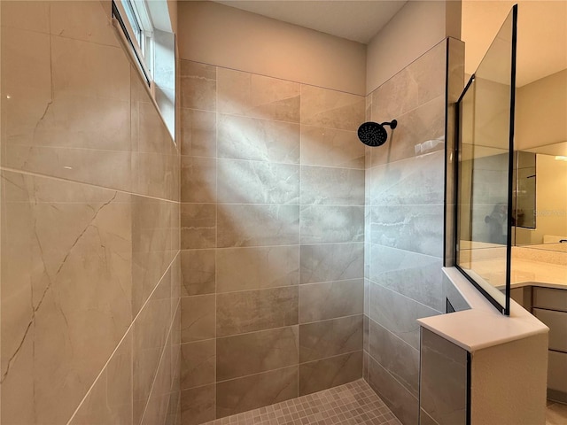 bathroom with vanity and tiled shower