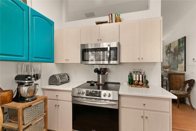 kitchen featuring visible vents, backsplash, appliances with stainless steel finishes, and light countertops