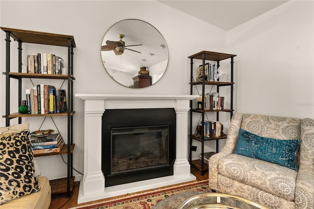 sitting room with ceiling fan and wood-type flooring