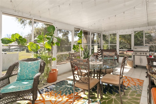 sunroom / solarium featuring track lighting and a healthy amount of sunlight