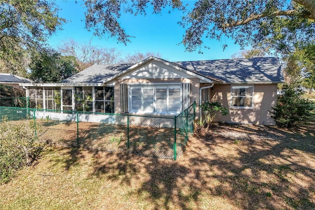 rear view of house featuring a yard and a sunroom