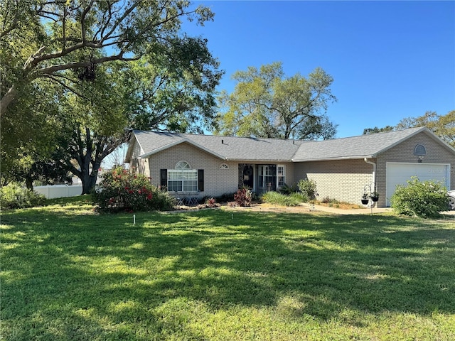 single story home featuring brick siding, a front lawn, a garage, and fence