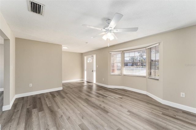 unfurnished room featuring hardwood / wood-style floors, ceiling fan, and a textured ceiling