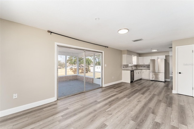 unfurnished living room featuring light hardwood / wood-style floors and sink