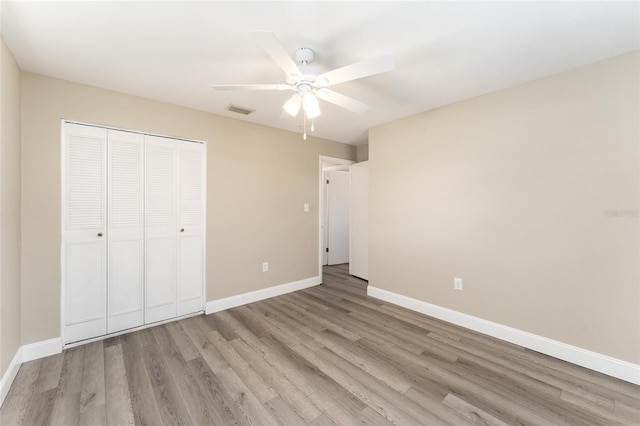 unfurnished bedroom featuring ceiling fan, a closet, and light hardwood / wood-style floors