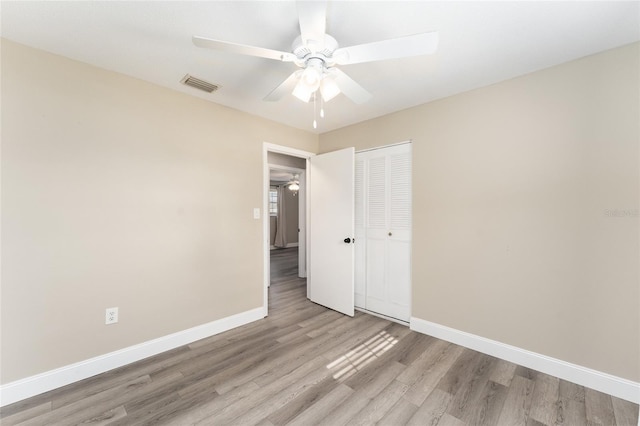 unfurnished bedroom with light wood-type flooring, a closet, and ceiling fan