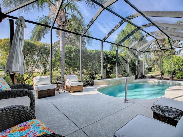 view of pool featuring a patio area, pool water feature, and glass enclosure