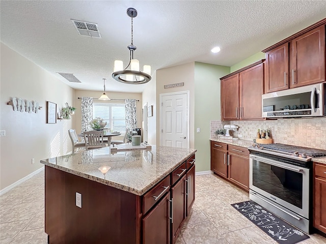 kitchen with light stone countertops, a center island, pendant lighting, decorative backsplash, and appliances with stainless steel finishes