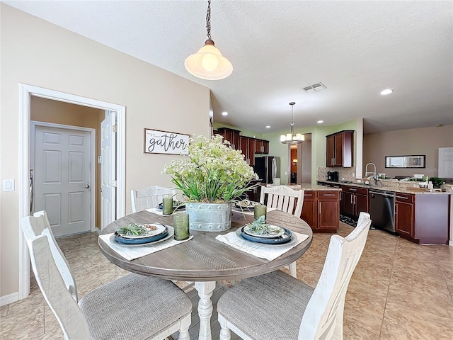 dining space with light tile patterned flooring, an inviting chandelier, and sink