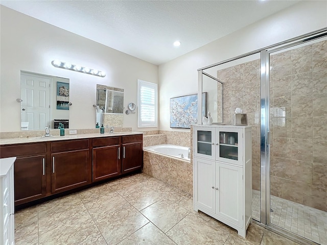 bathroom featuring tile patterned flooring, vanity, a textured ceiling, and shower with separate bathtub