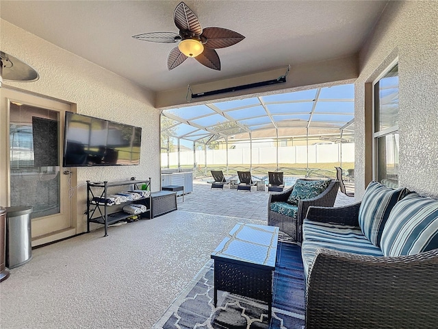 view of patio featuring an outdoor living space, ceiling fan, and glass enclosure