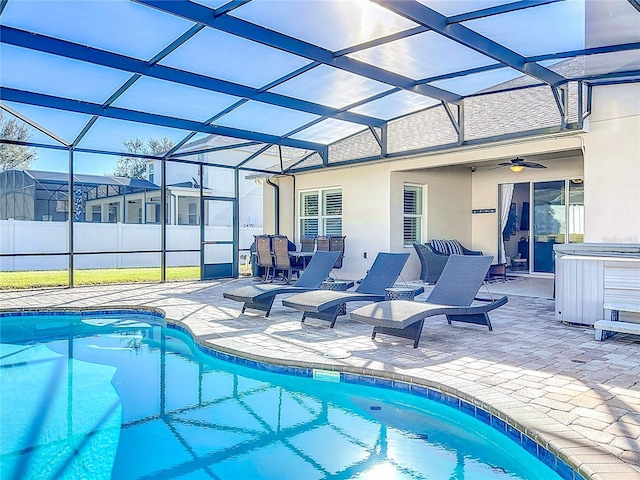 view of swimming pool featuring a patio, glass enclosure, and ceiling fan