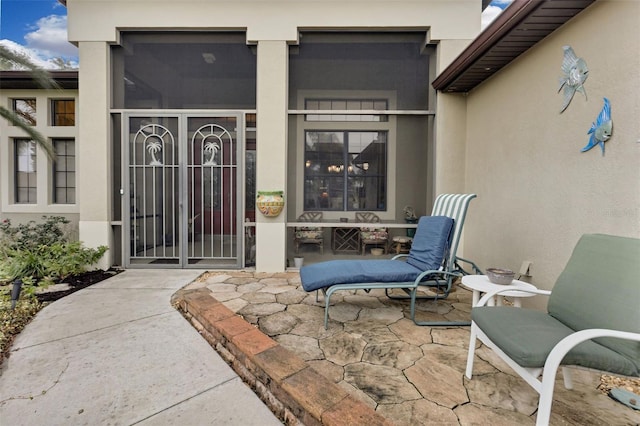 view of exterior entry with a patio area