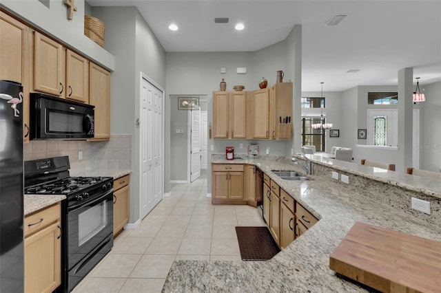 kitchen featuring pendant lighting, sink, light tile patterned floors, and black appliances