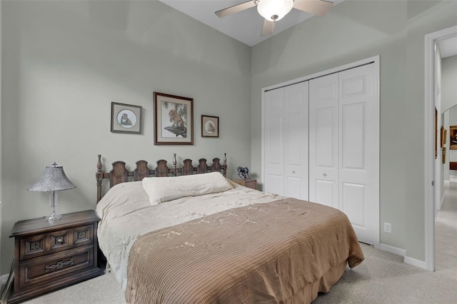 bedroom with ceiling fan, a closet, and light carpet