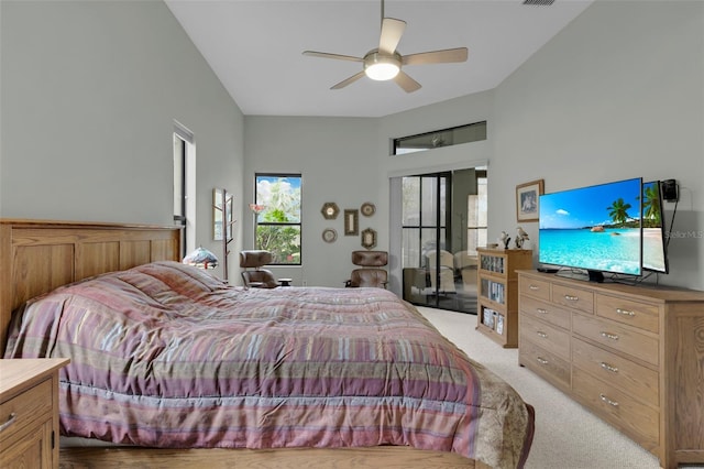 bedroom with light carpet, visible vents, a high ceiling, and a ceiling fan