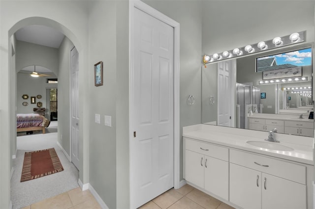 ensuite bathroom featuring tile patterned flooring, ensuite bath, vanity, and baseboards