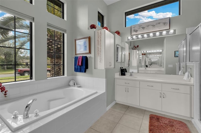 full bathroom with a bath, tile patterned flooring, vanity, and a high ceiling