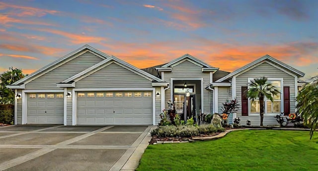 view of front of property with a garage and a lawn