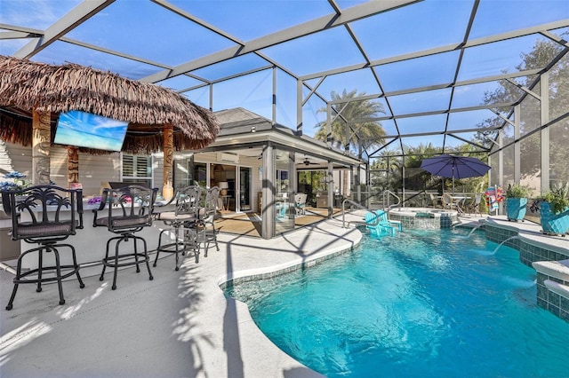 view of swimming pool with an in ground hot tub, pool water feature, a lanai, ceiling fan, and a patio area