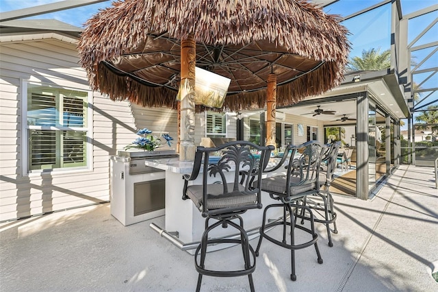 view of patio / terrace featuring exterior kitchen, an outdoor bar, and ceiling fan