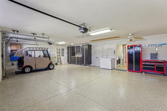 garage with a garage door opener, electric panel, and washer / dryer