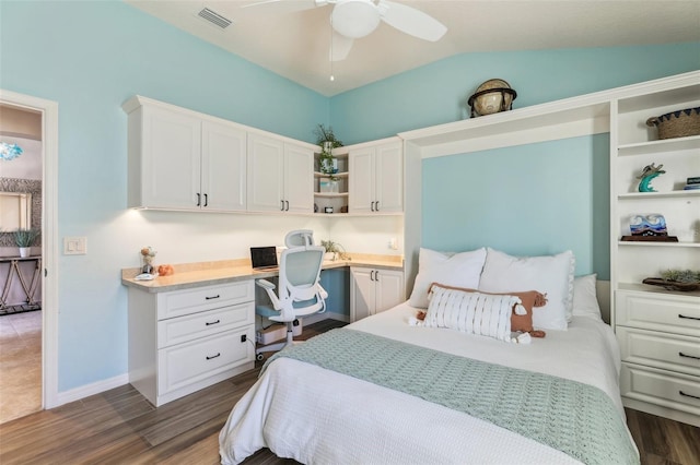 bedroom with lofted ceiling, built in desk, dark hardwood / wood-style floors, and ceiling fan