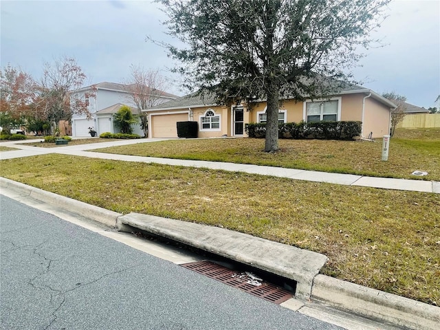 single story home featuring a front lawn and a garage