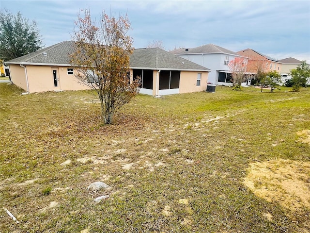 back of property featuring a yard and a sunroom