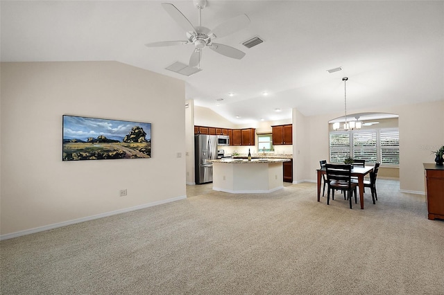 living room with light colored carpet, vaulted ceiling, and ceiling fan with notable chandelier