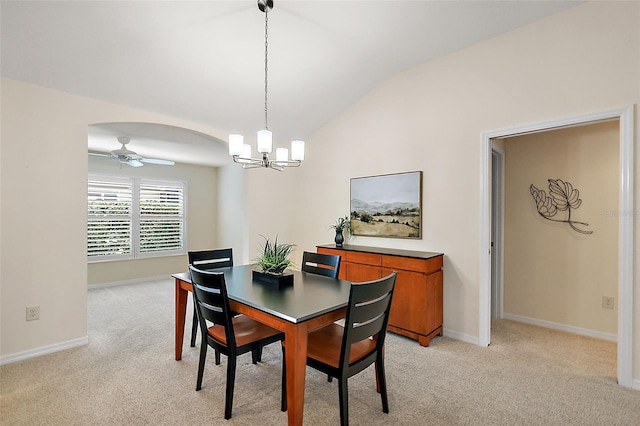 dining area with light colored carpet, lofted ceiling, and ceiling fan with notable chandelier