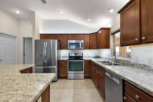 kitchen featuring stainless steel appliances, light tile patterned floors, light stone counters, sink, and lofted ceiling