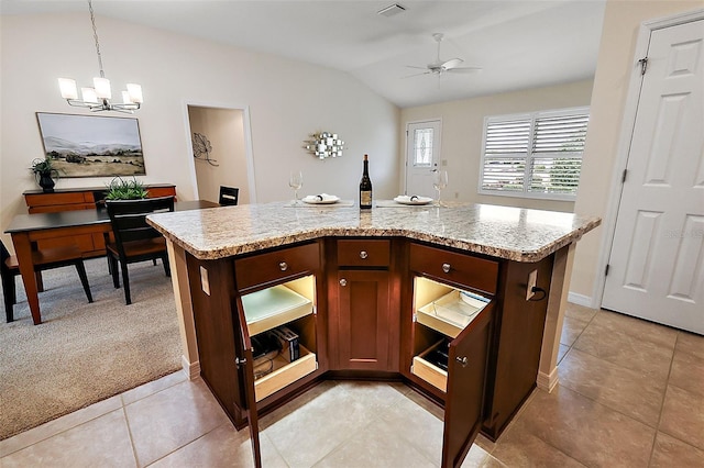 kitchen featuring vaulted ceiling, light colored carpet, a kitchen island, decorative light fixtures, and ceiling fan with notable chandelier